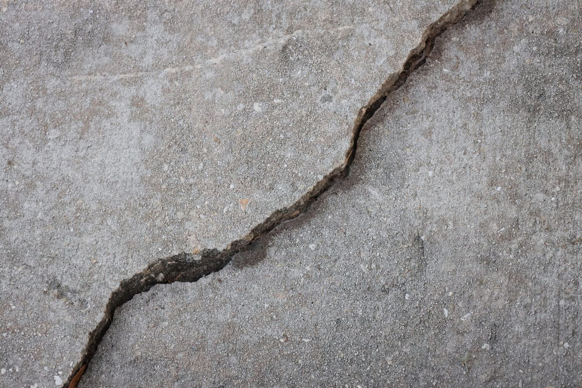 Long jagged crack running diagonally across a concrete slab